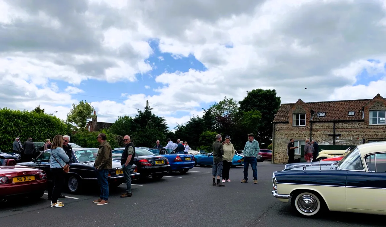 Members chatting among classic and modern-classic cars