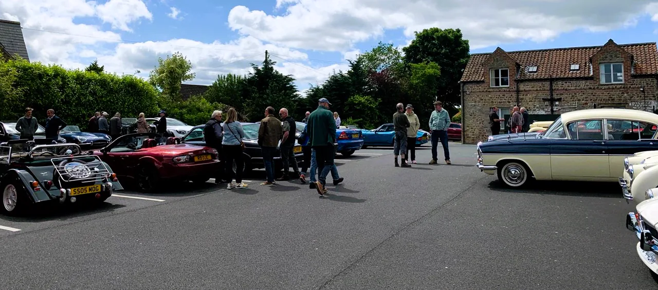 Wide view of a Club RetroTorque meeting with people and cars