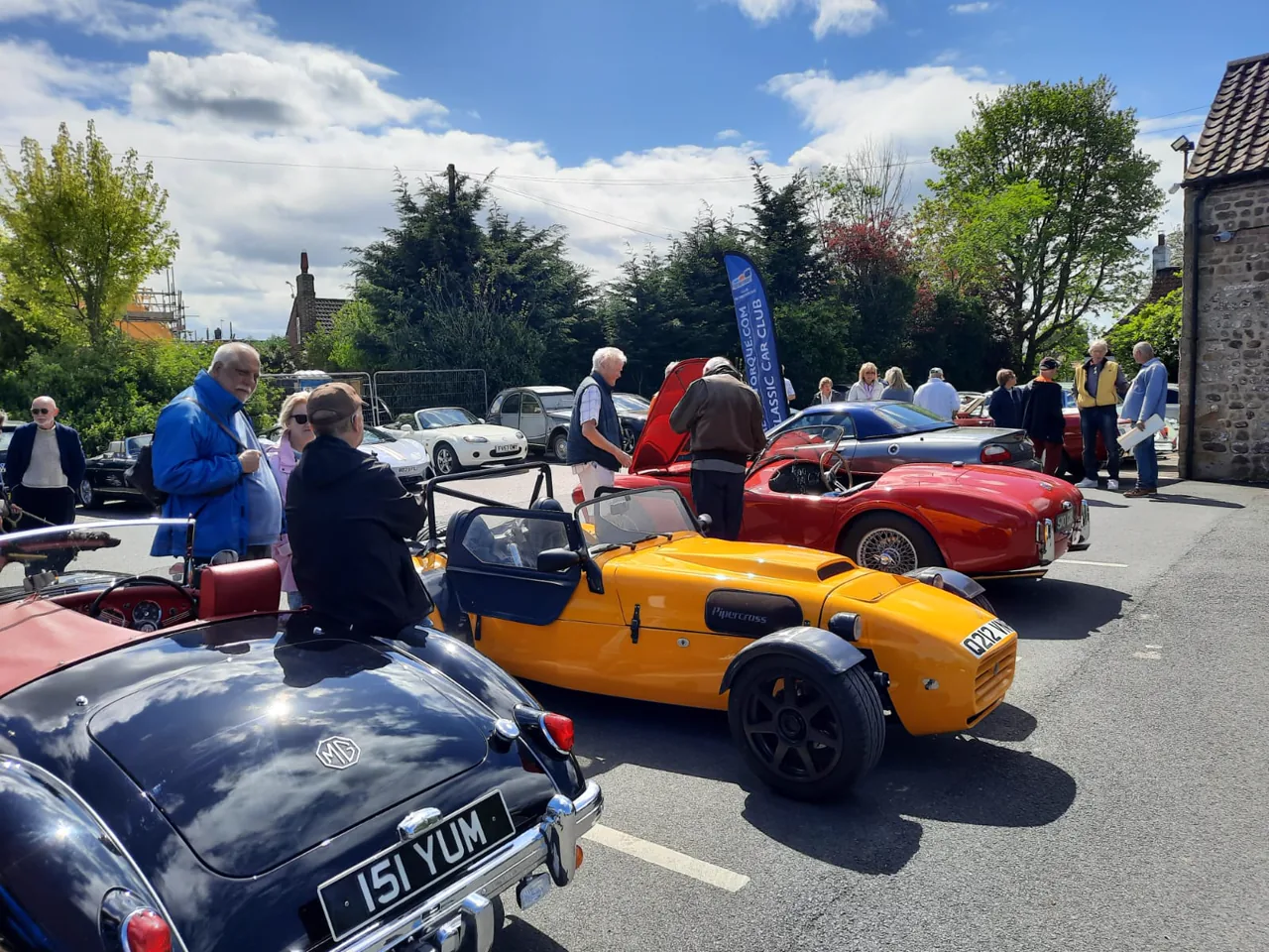 Club members talking among an varied line-up of classic cars