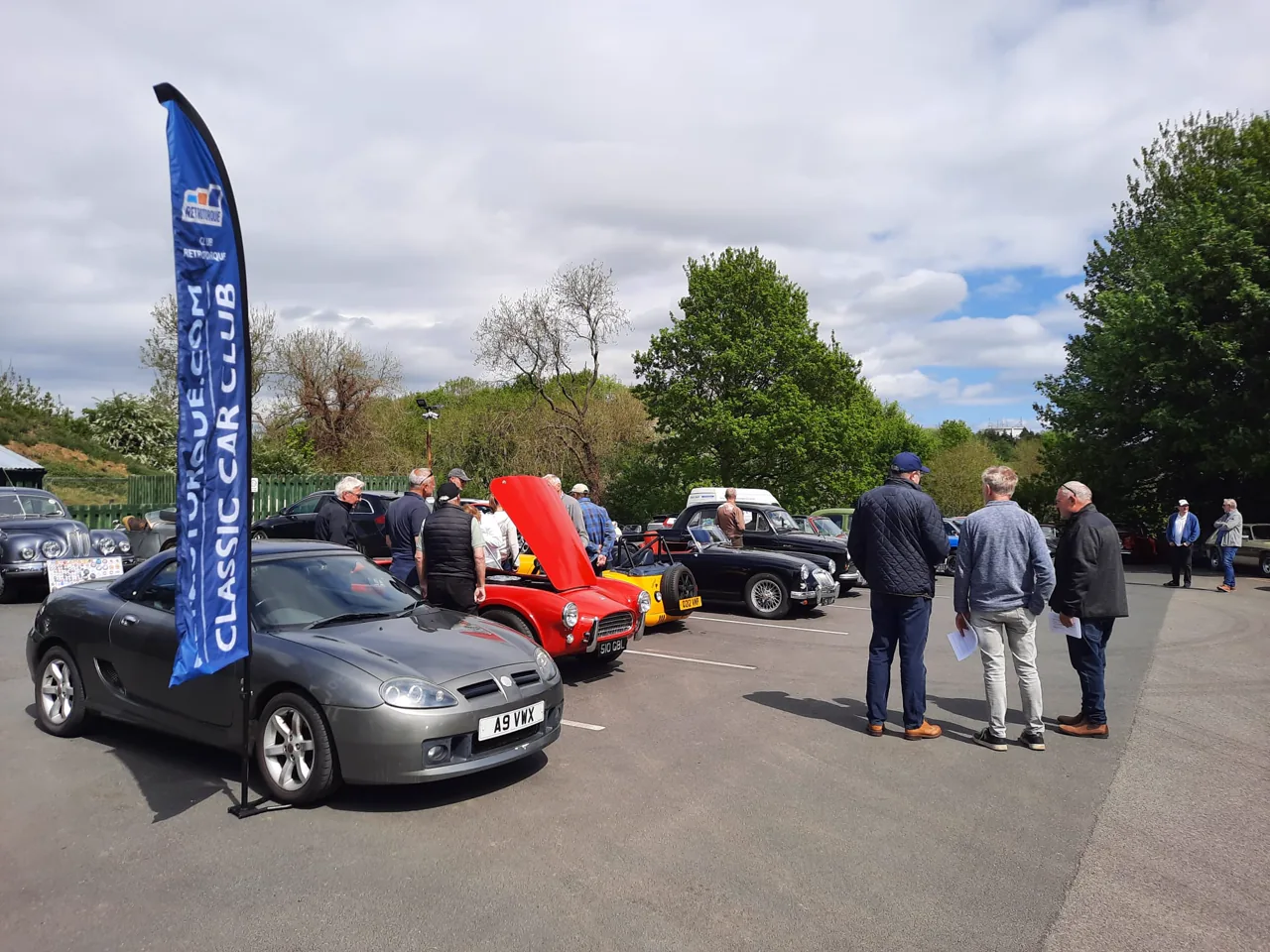 Club RetroTorque flag beside people and classic cars