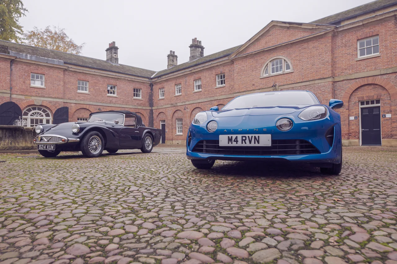 Classic and modern sporting cars arranged in a courtyard