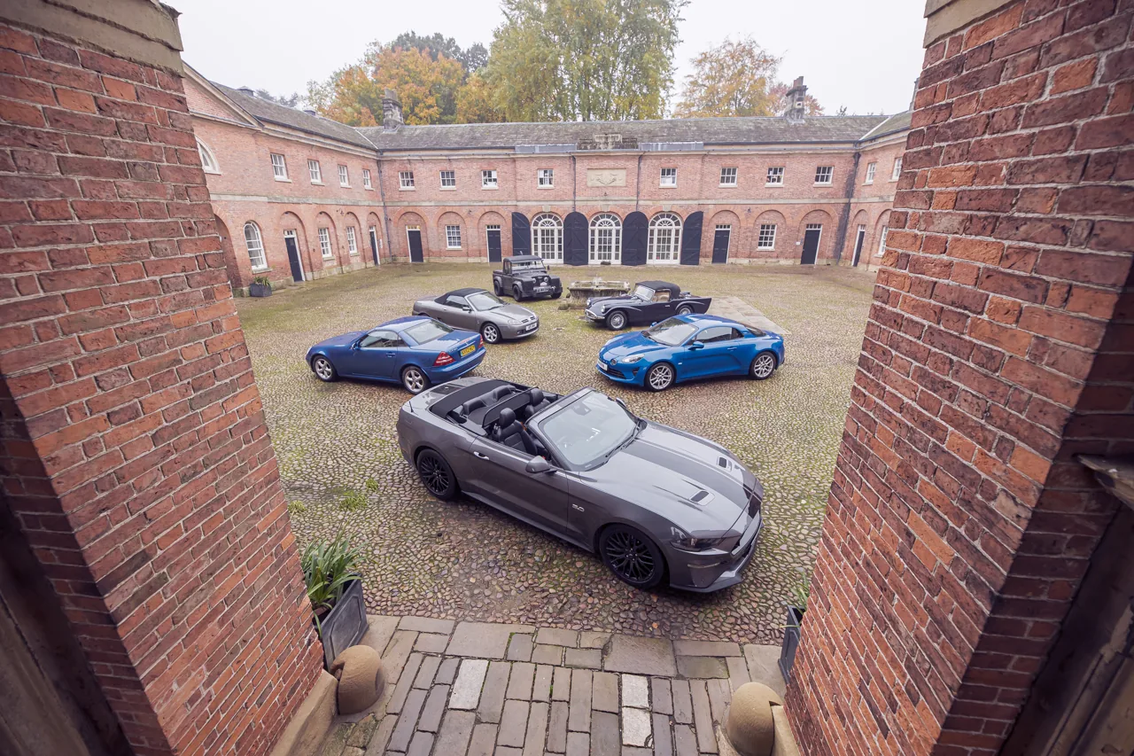 A varied RetroTorque car line-up in a historic courtyard